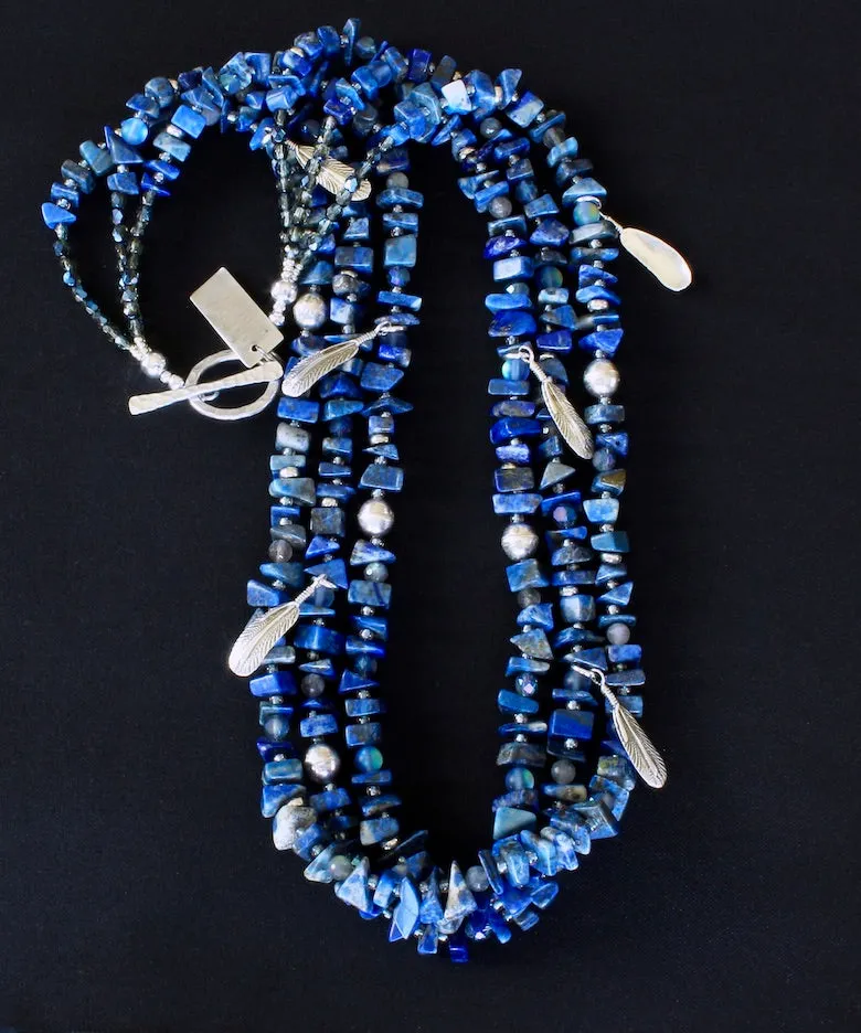 Lapis Lazuli Nugget 3-Strand Necklace with Bench-Made Sterling Silver Rounds, Sterling Silver Feather Charms, Translucent Blue Crystal Rounds, Labradorite Faceted Rounds, Fire Polished Glass, and Hammered Sterling Silver Toggle Clasp
